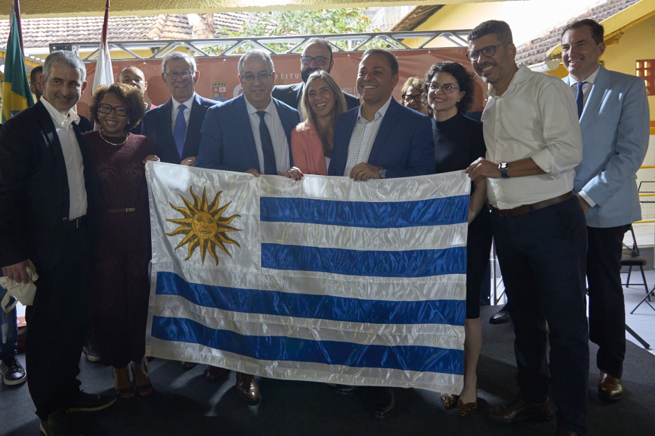 Ministro Mahía desarrolla una intensa agenda en el marco de la Semana de Uruguay en Río Autoridades posan para foto con la bandera uruguaya