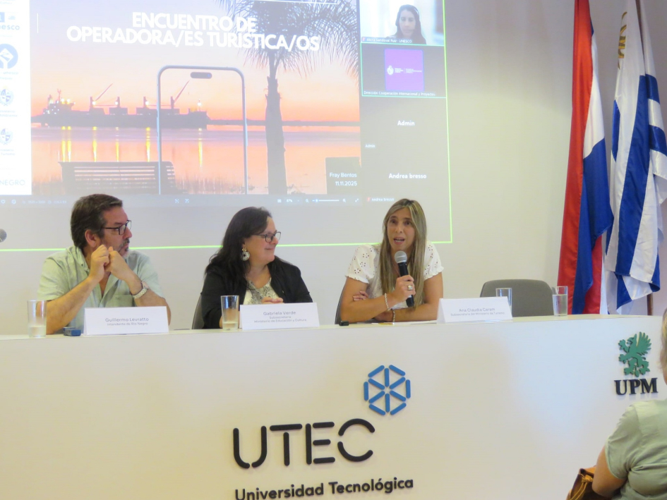 Encuentro de Rutas Unesco en Fray Bentos fortalece la promoción y gestión sostenible. Plano general de personas en mesa.