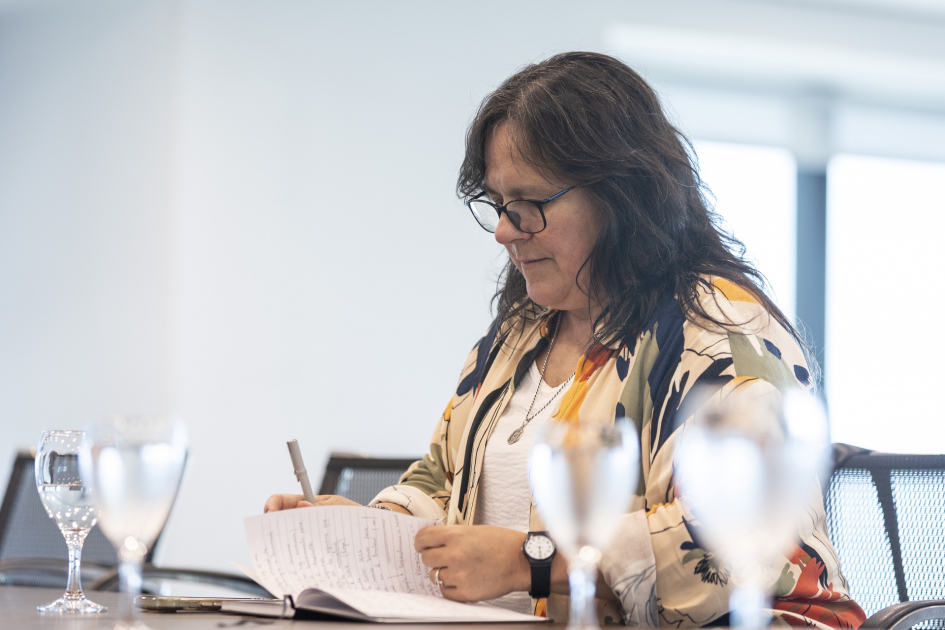 Ministra (i) pasando hojas de un cuaderno