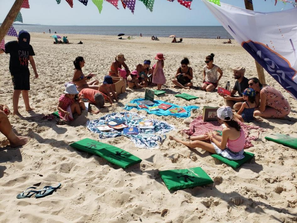 Niños, niñas y jóvenes leyendo en la playa Niños, niñas y jóvenes leyendo en la playa