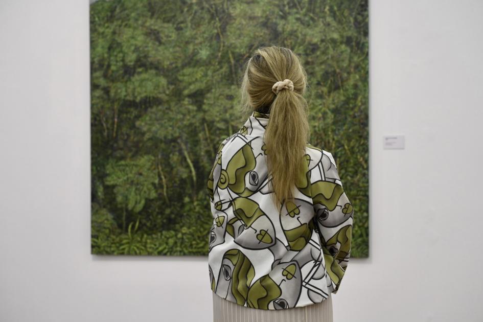 La muestra permite recorrer los principales períodos de la obra del artista plástico. Persona viendo pintura.