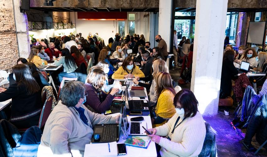 Lugar de trabajo con todos los participantes sentados en mesas Lugar de trabajo con todos los participantes sentados en mesas