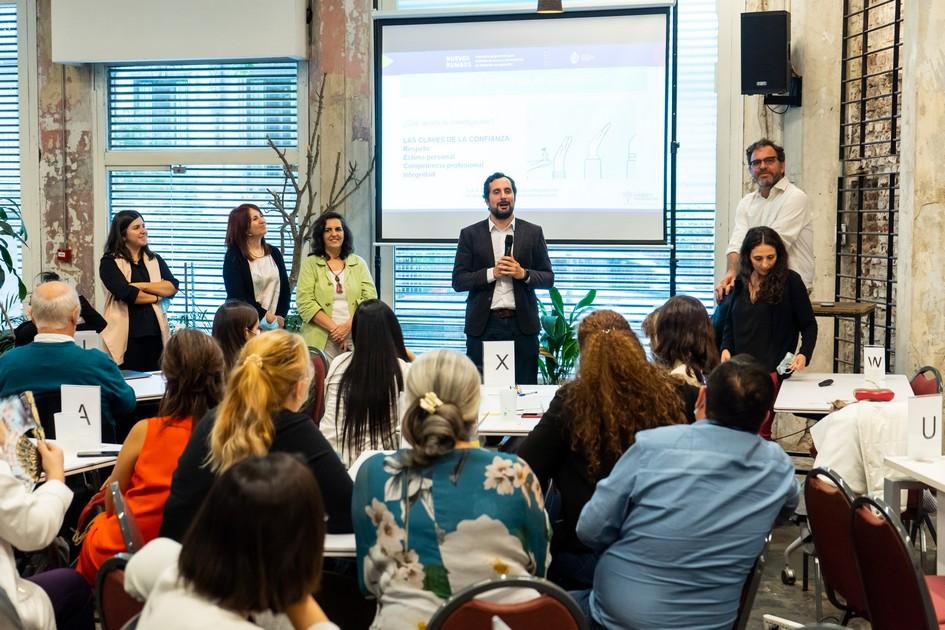 Director de Educación hablando y a sus costados los docentes. Adelante están los participantes