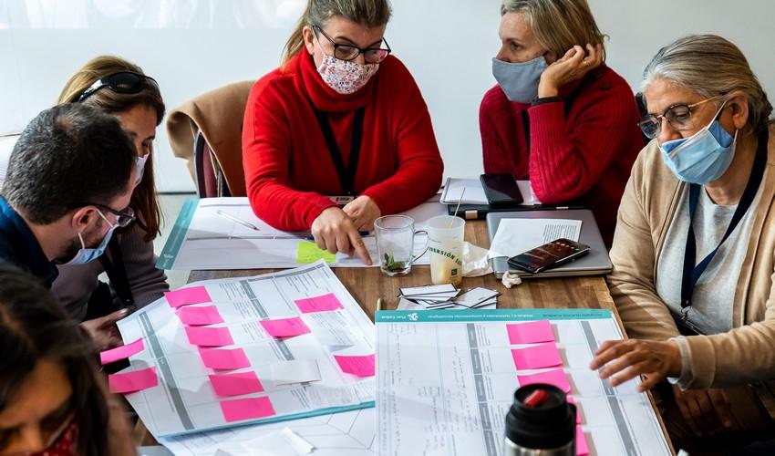 Personas trabajando completando una tabla con papeles