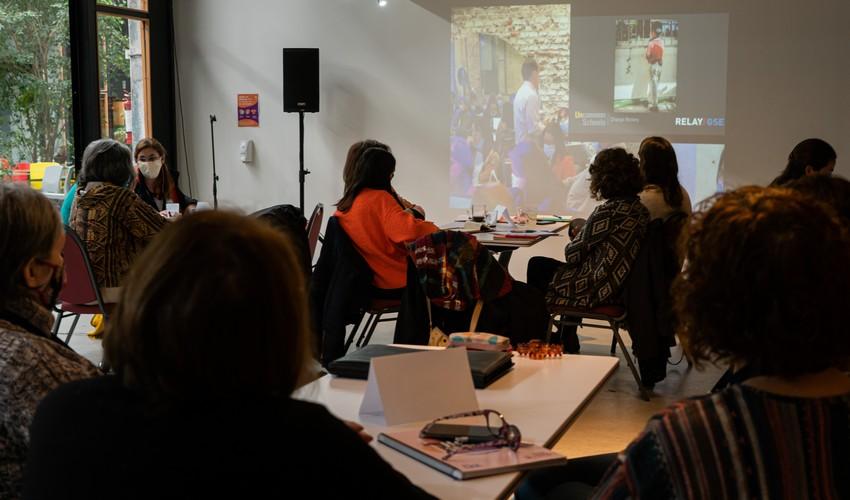 Participantes mirando la pantalla donde un proyector está pasando imágenes