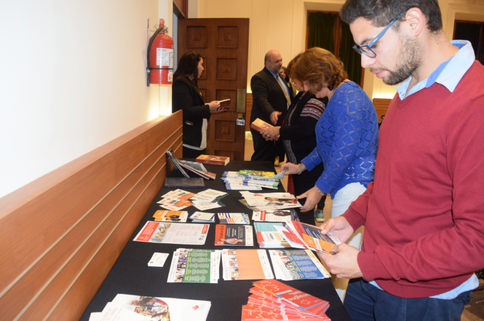 Lanzamiento del Ciclo de charlas, becas y oportunidades de formación Personas mirando la mesa de folletos educativos