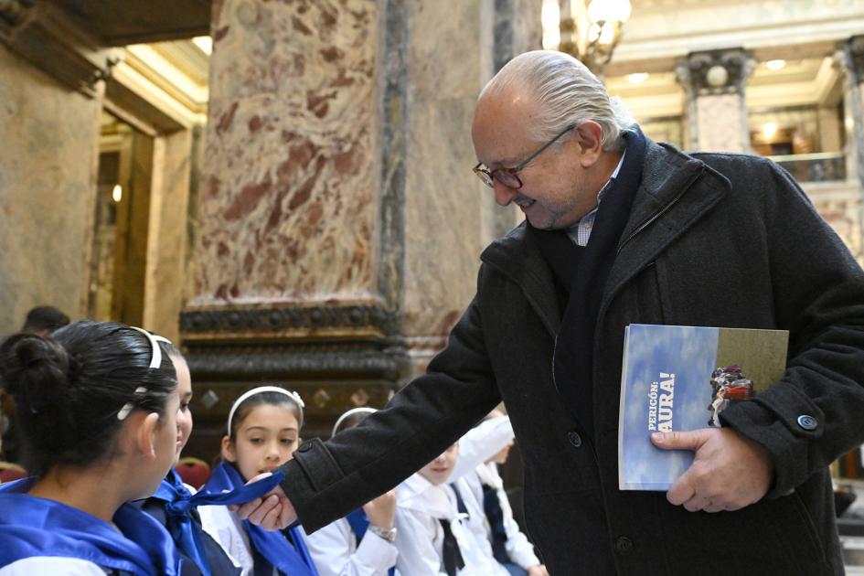 Ministro saludando a niños.