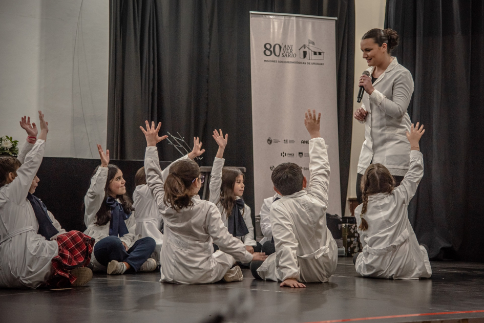 Las Misiones Sociopedagógicas revalorizan el rol docente al cumplirse 80 años de su creación. Escolares en ronda levantando la mano con la maestra en frente
