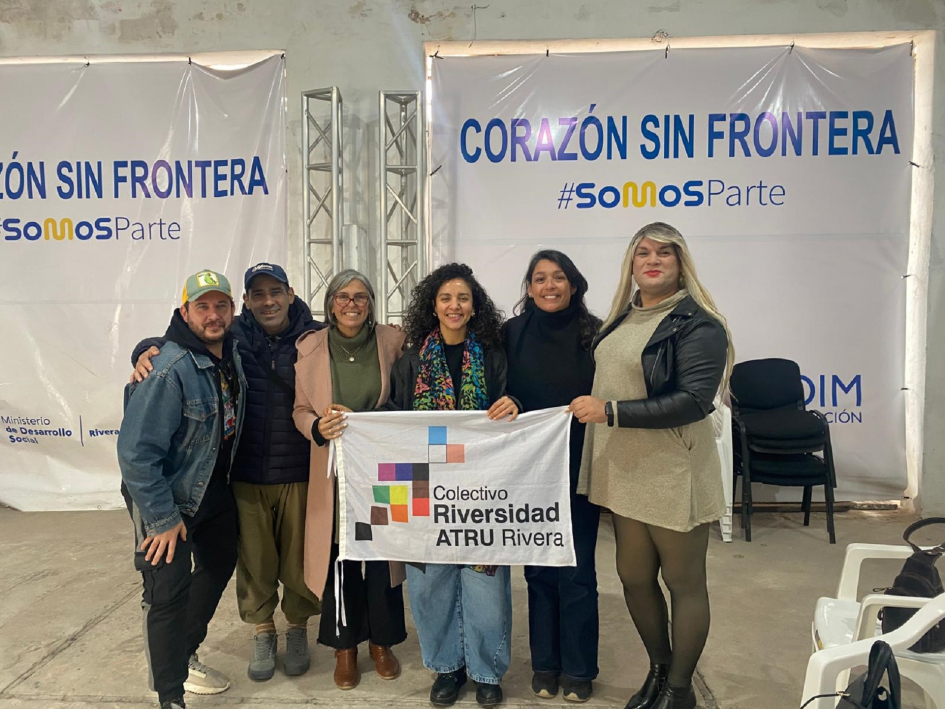 La delegación institucional que acompañó a la ministra se reunió con el colectivo ATRU. Personas en fila posan para foto