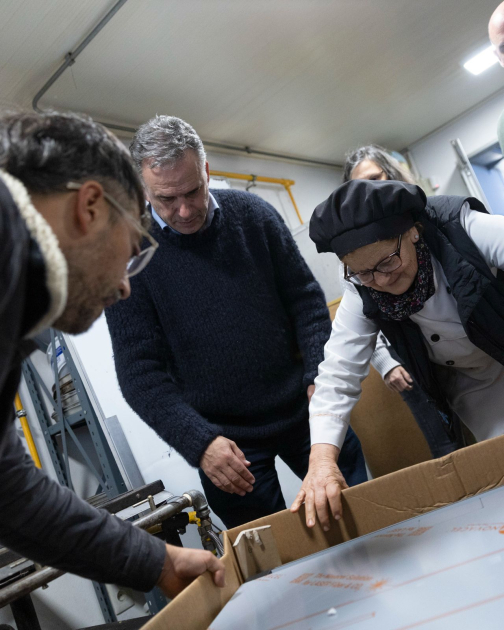 Taller de panadería de Cecap Brazo Oriental recibió horno prometido por Orsi Personas abriendo una caja