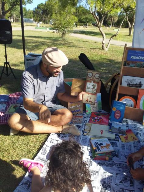 Adulto mostrando un libro a niños y niñas