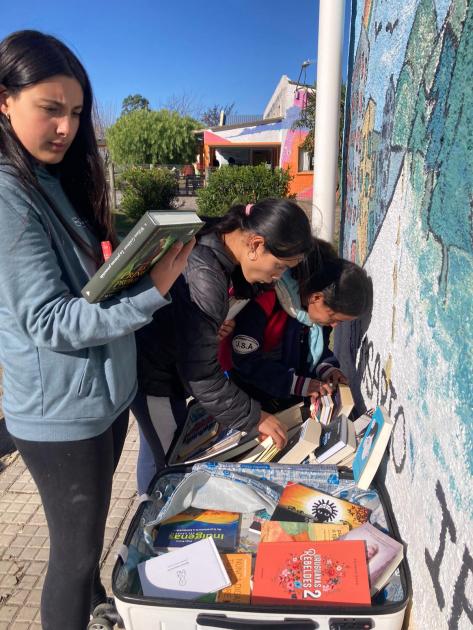 Teleo Personas revisando una maleta con libros.
