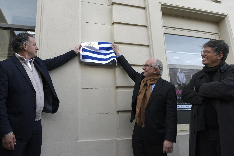 Personas quitando bandera para descubrir placa de declaración