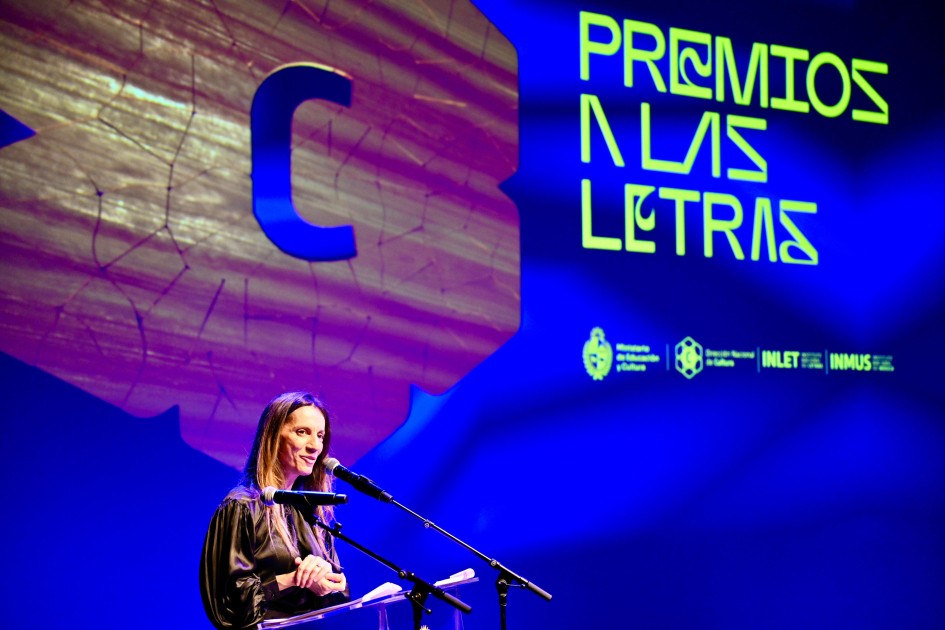Letras y Música reconocidas en primera edición del Premio a las Artes Coordinadora del Instituto Nacional de Letras hablando al público.