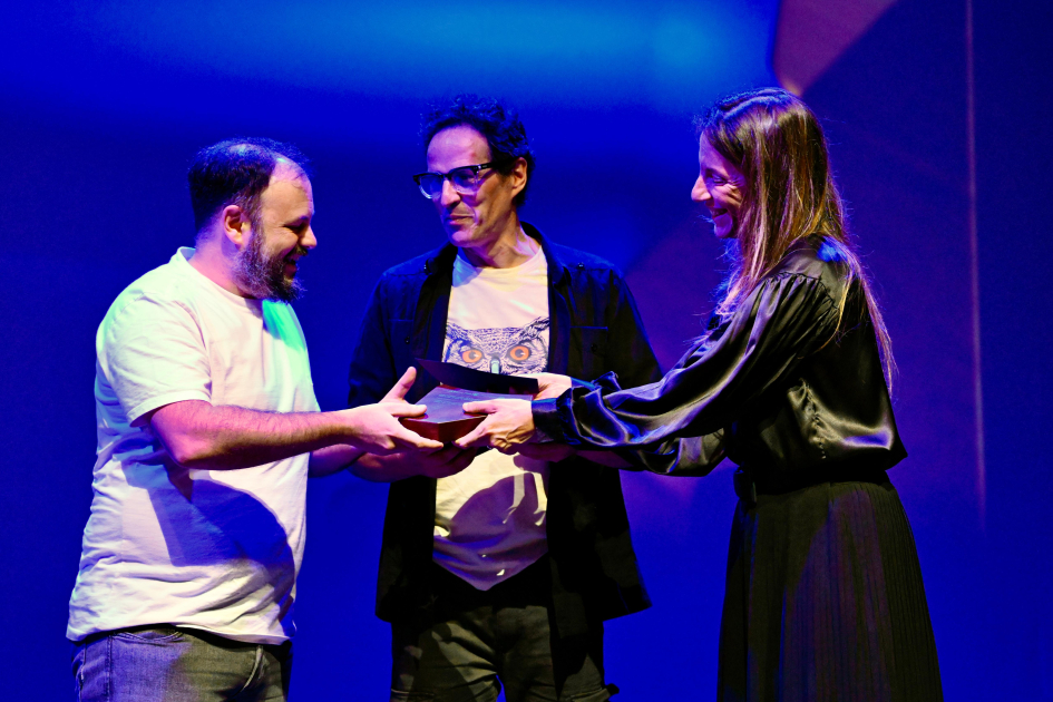 Letras y Música reconocidas en primera edición del Premio a las Artes Personas entregando el premio.