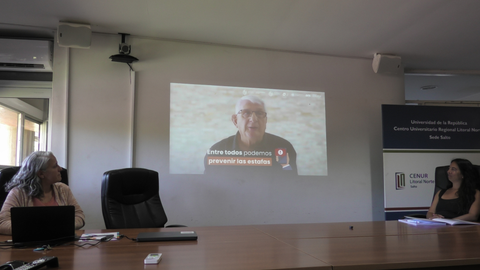 Personas en mesa mirando un video