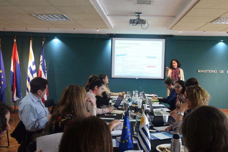 Cristina Gómez (España) exponiendo Personas sentadas al rededor de la mesa mirando la presentación