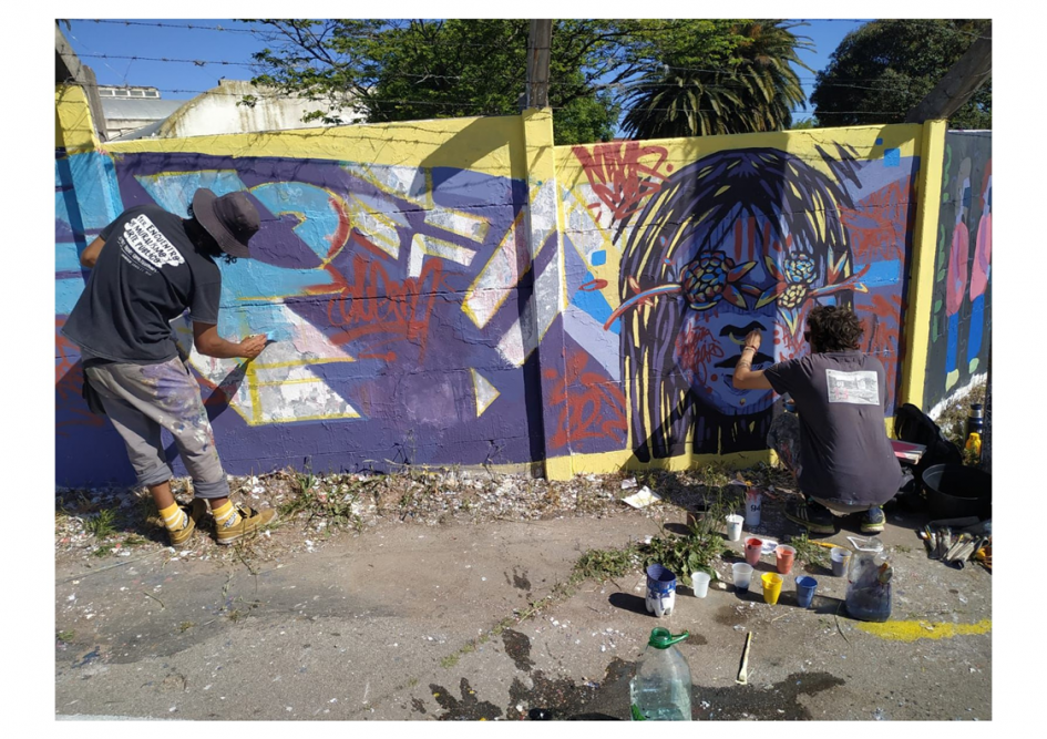 Intervención artística en barrio Ituzaingó dos personas pintando un pintura mural