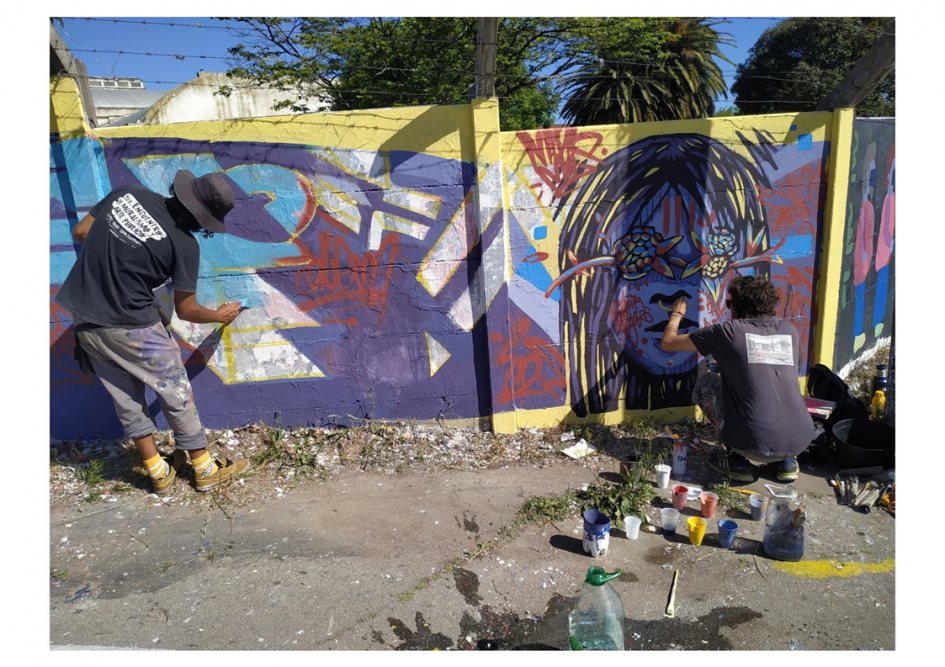 dos personas pintando un pintura mural