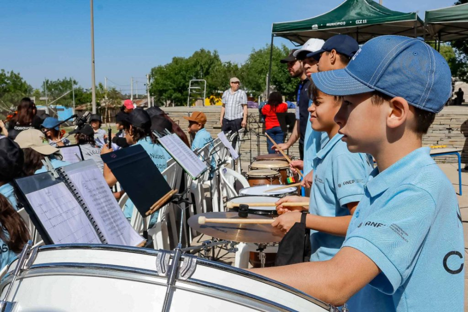 Niñas y niños tocando instrumentos musicales.