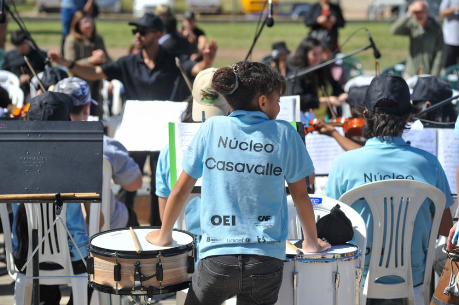 Niños de espaldas tocando música.