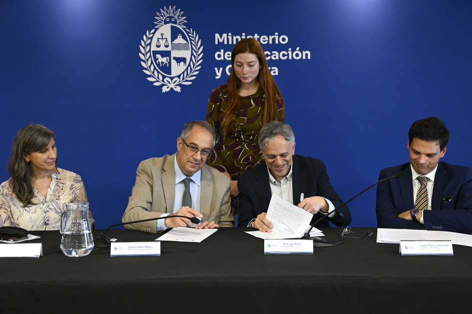 Personas firmando un documento.