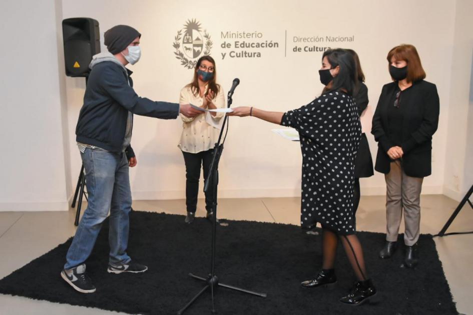 Entregando los diplomas de las menciones Entregando los diplomas de las menciones