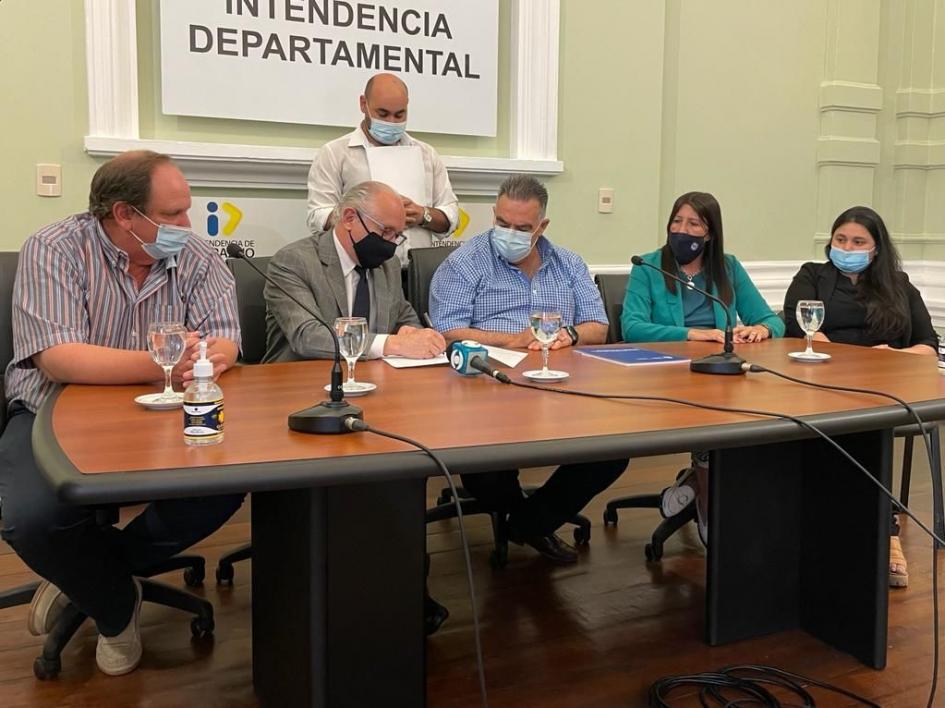 Autoridades en una mesa hablando y firmando el convenio