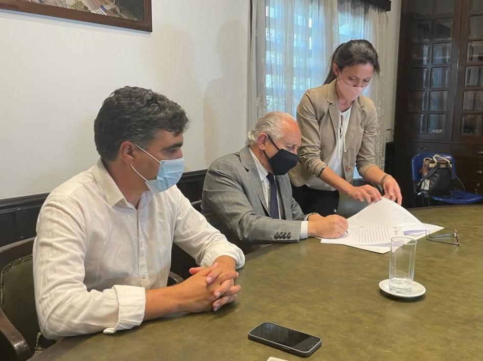 Intendente de Salto viendo como firma el convenio el ministro