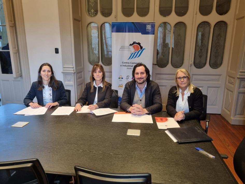 Director Gonzalo Baroni junto a representantes empresariales Tres mujeres y un hombre sentados frente a una mesa con varios documentos