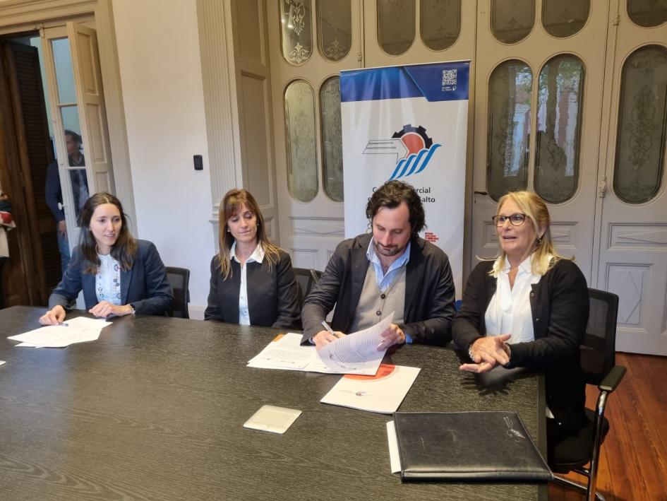 Director Gonzalo Baroni junto a representantes empresariales Tres mujeres y un hombre sentados frente a una mesa con varios documentos