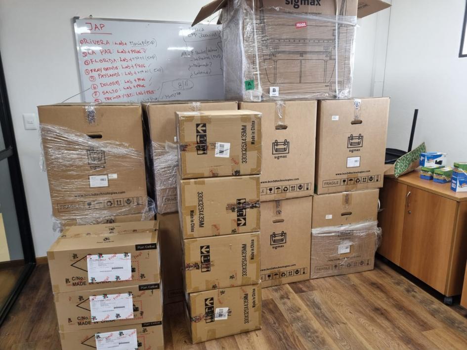 Equipos entregados por Ceibal para los centros Cecap Cajas apiladas que contienen equipos de Ceibal