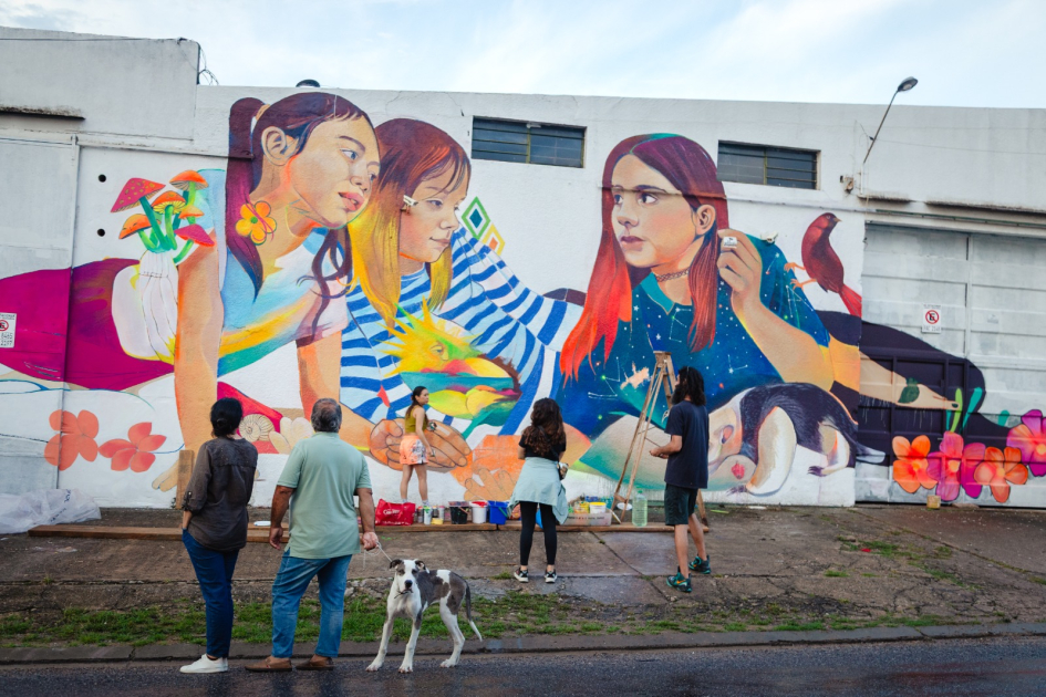 Artistas frente a un mural