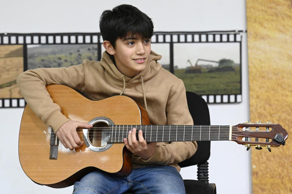 Estudiante de música del centro con su guitarra durante el acto de nominación.