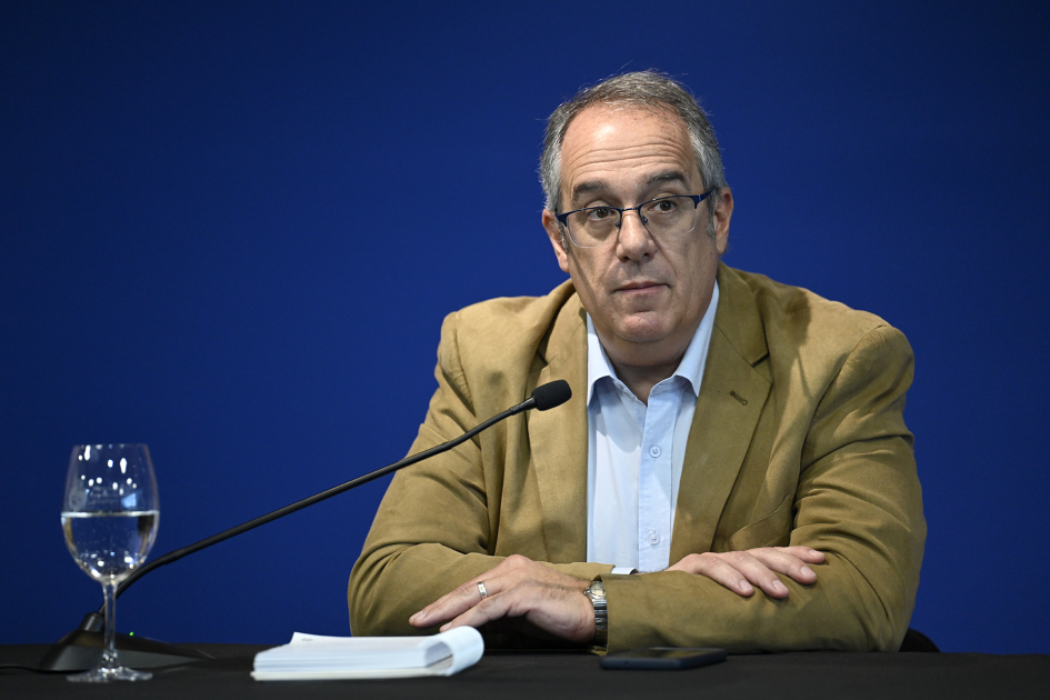 Ministro en mesa habla al público