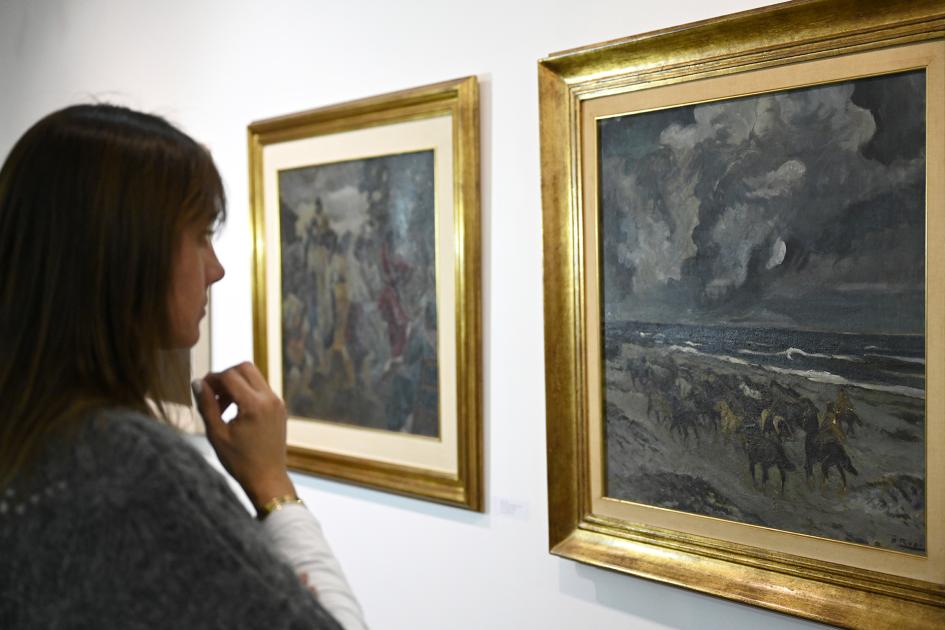 Mujer observa un cuadro de Manuel Rosé durante la inauguración de la muestra.