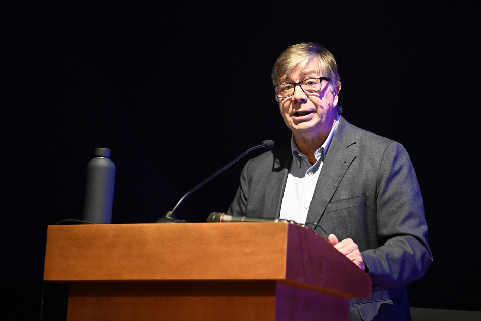 Conferencista habla al público desde un atril