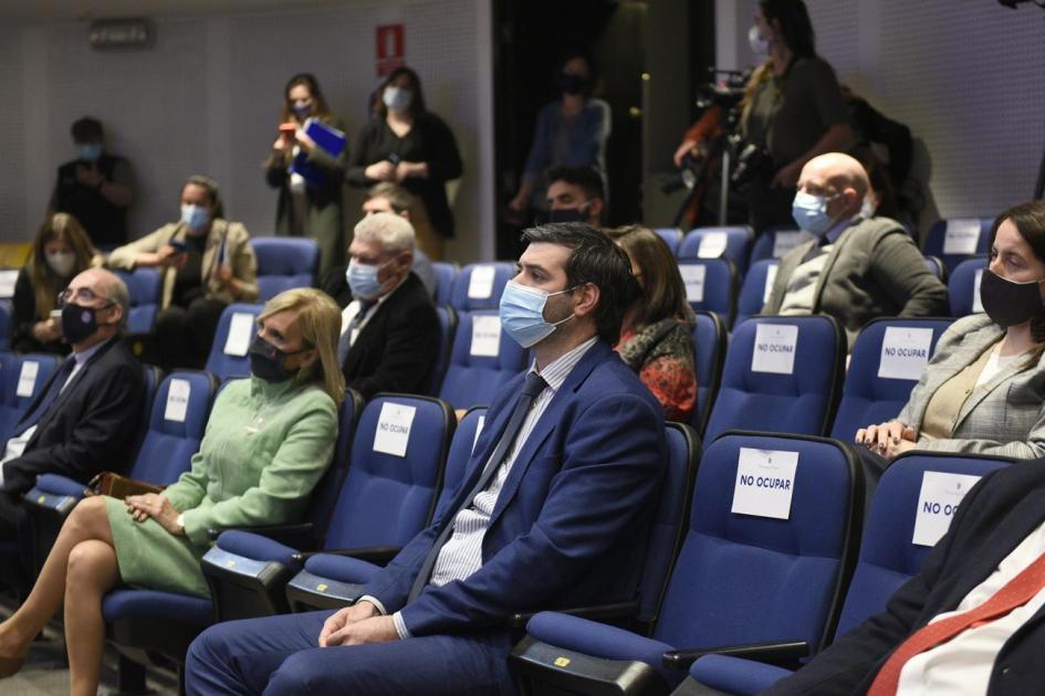 Personas sentadas en sillas de la sala de Actos