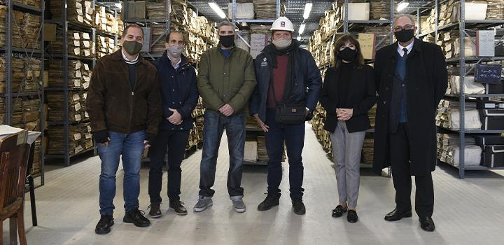 Personas posando frente a las estanterías frente a los archivos