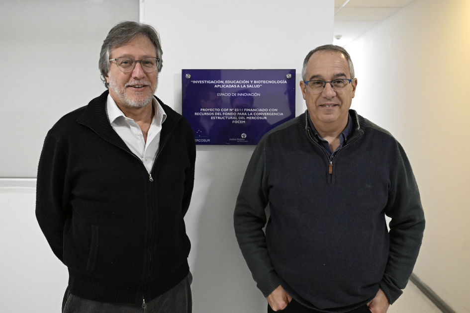 Ministro y director del Institut Pasteur frente a placa dentro de la institución