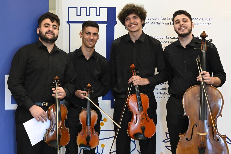 Cuatro jóvenes con instrumentos en las manos.