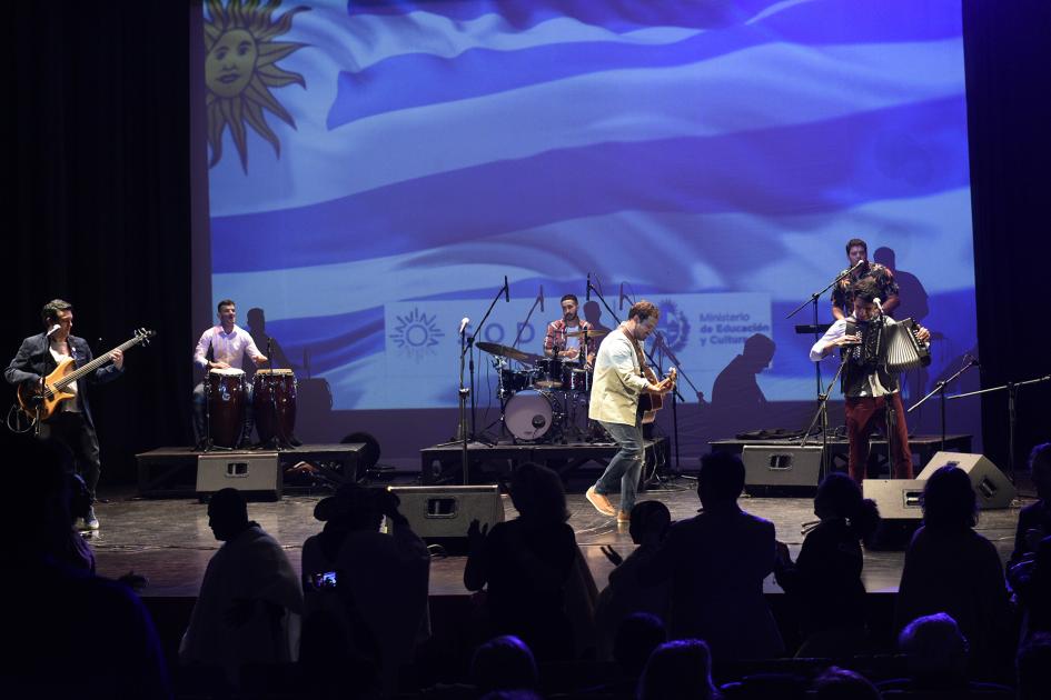 Personas tocando instrumentos en el escenario.