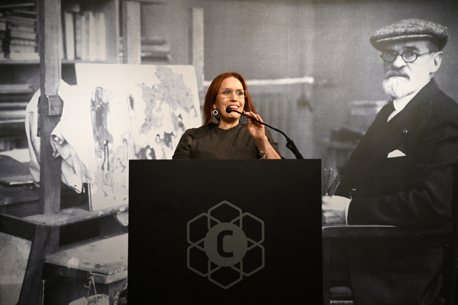Directora Nacional de Cultura habla al público desde un atril
