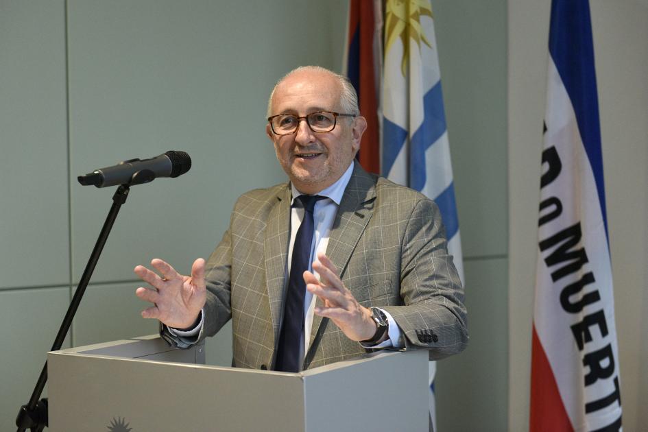 Hombre con manos apoyadas en un atril y sonriendo