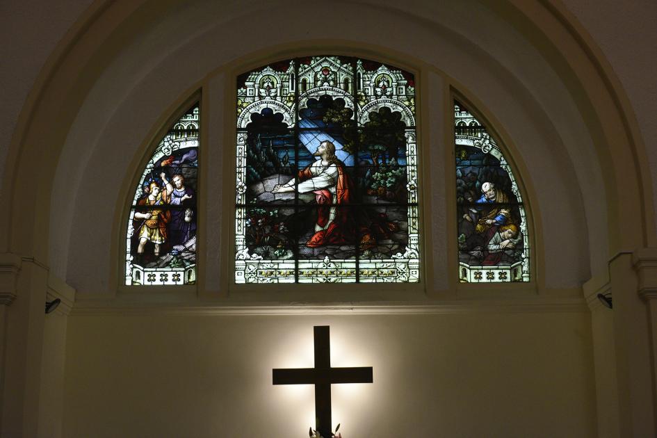 Foto de la cruz con vitró detrás