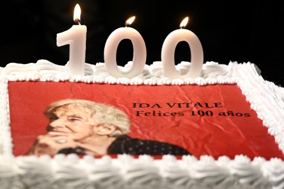 Torta de cumpleaños de Ida Vitale, con una foto de ella impresa y el número 100 en velas.
