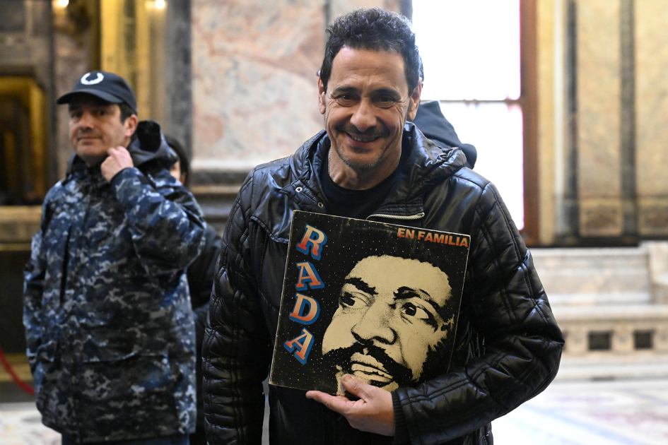 Hombre posa para foto con un disco de Rada en la mano