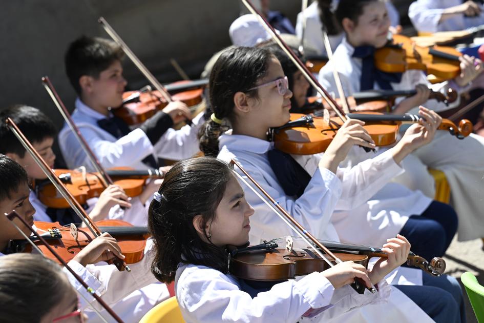 Escolares tocando instrumentos de música.