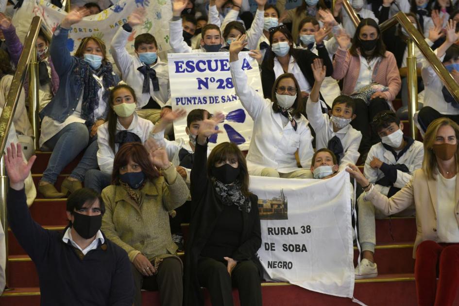 Alumnos y autoridades sentados en la escalera de entrada del Sodre saludando a la cámara