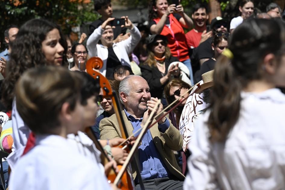 Escolares tocando instrumentos de música y público.